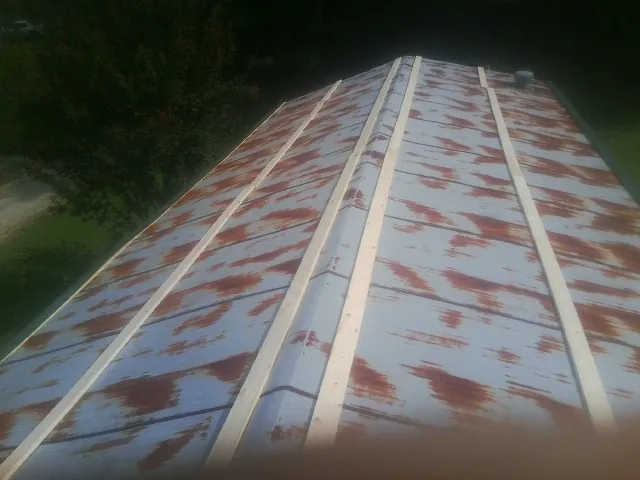Rusted metal roof panels with new wood purlins before replacement — Storm Damage Roof Repair in Molt by Roofing Brothers